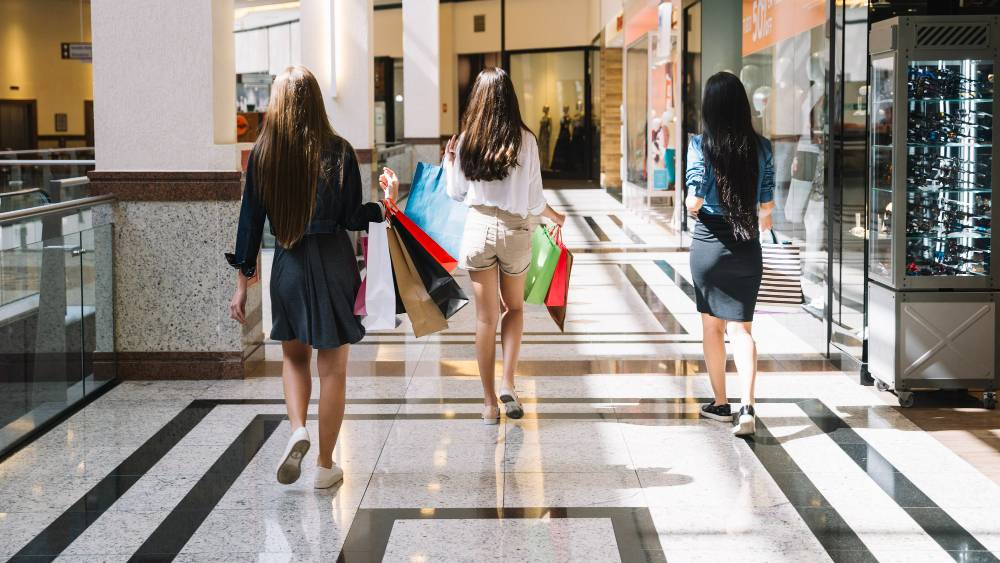 foto de três mulheres passeando em um centro comercial