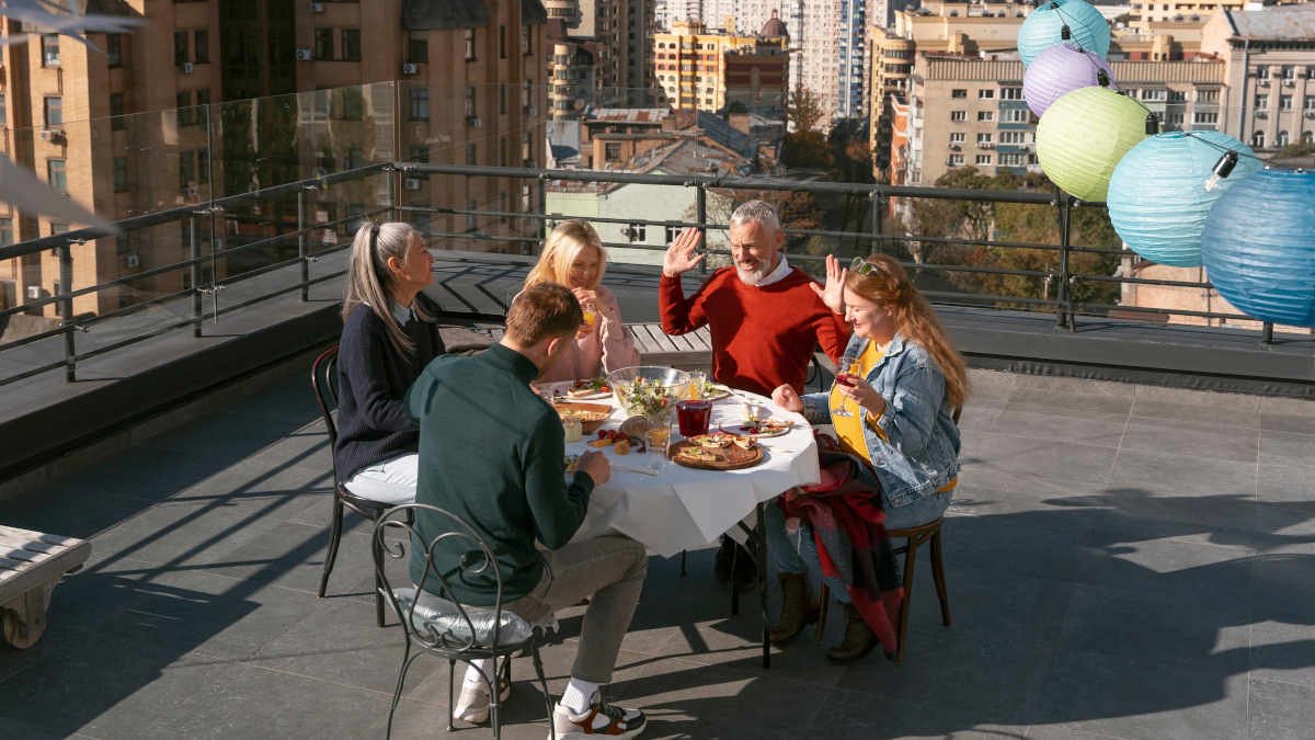 Grupo de amigos aproveitando um almoço ao ar livre em um terraço.