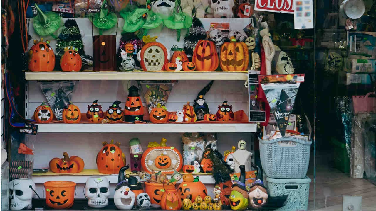 Estante cheia de abóboras de decoração e itens de Halloween.