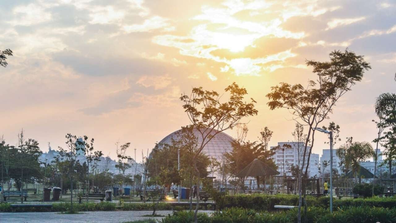 pôr do sol no Parque Villa-Lobos, em São Paulo, com a estrutura do anfiteatro ao fundo.