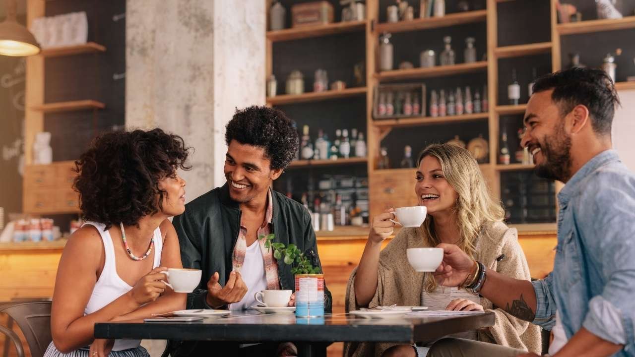 grupo de amigos aproveitando um momento descontraído em uma cafeteria charmosa.