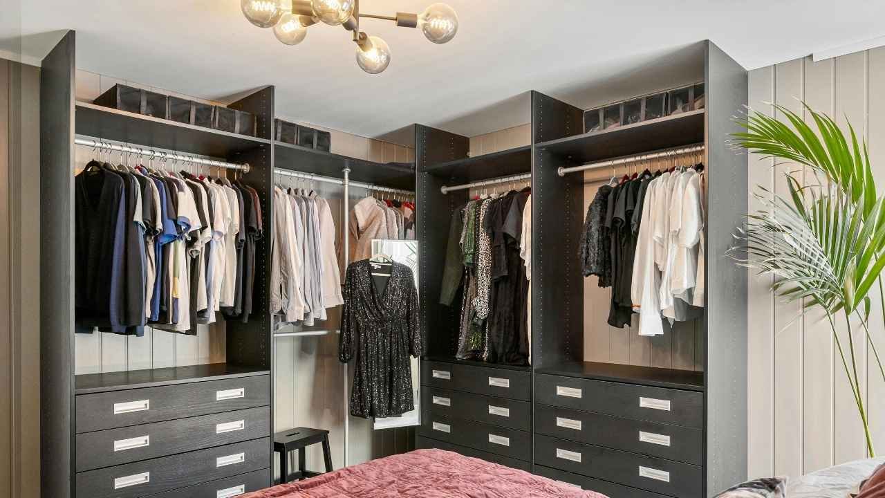 guarda-roupa organizado com roupas penduradas e caixas no topo.
