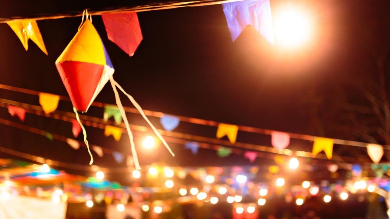 bandeirinhas coloridas e balão decorativo iluminado à noite.