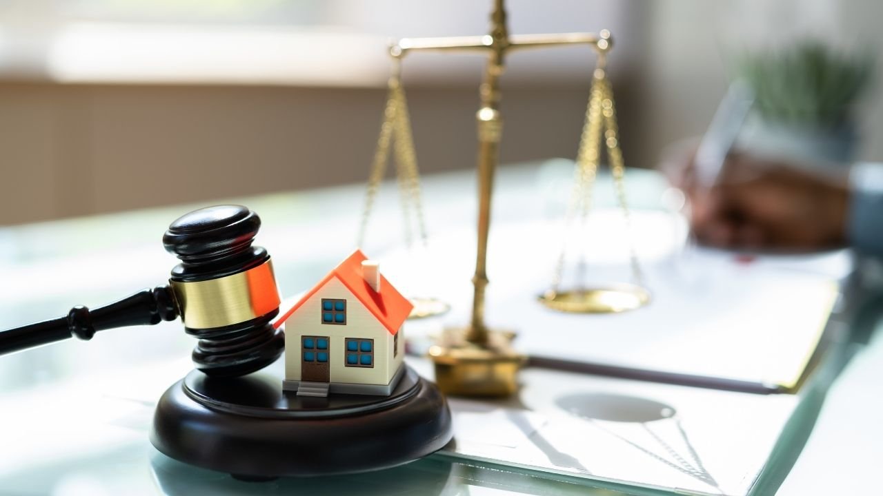 miniatura de casa ao lado de martelo da justiça.
