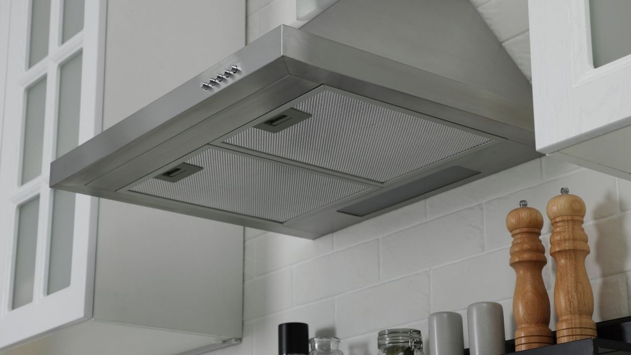 coifa de inox instalada em armário de cozinha moderna.