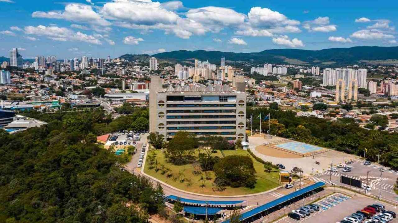 Foto diurna da Prefeitura de Jundiaí com a cidade e a Serra do Japi ao fundo.