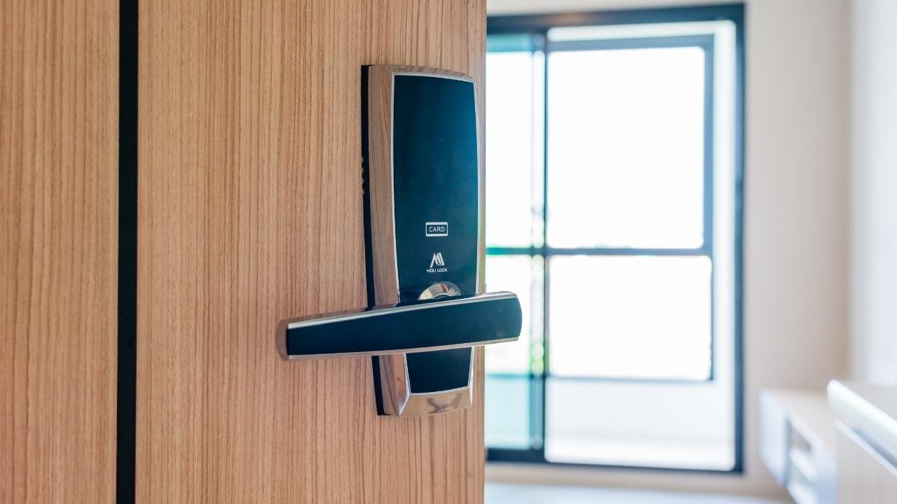 Fechadura eletrônica instalada em uma porta de madeira, com maçaneta, realçando o design e a funcionalidade de uma fechadura eletrônica para apartamento.
