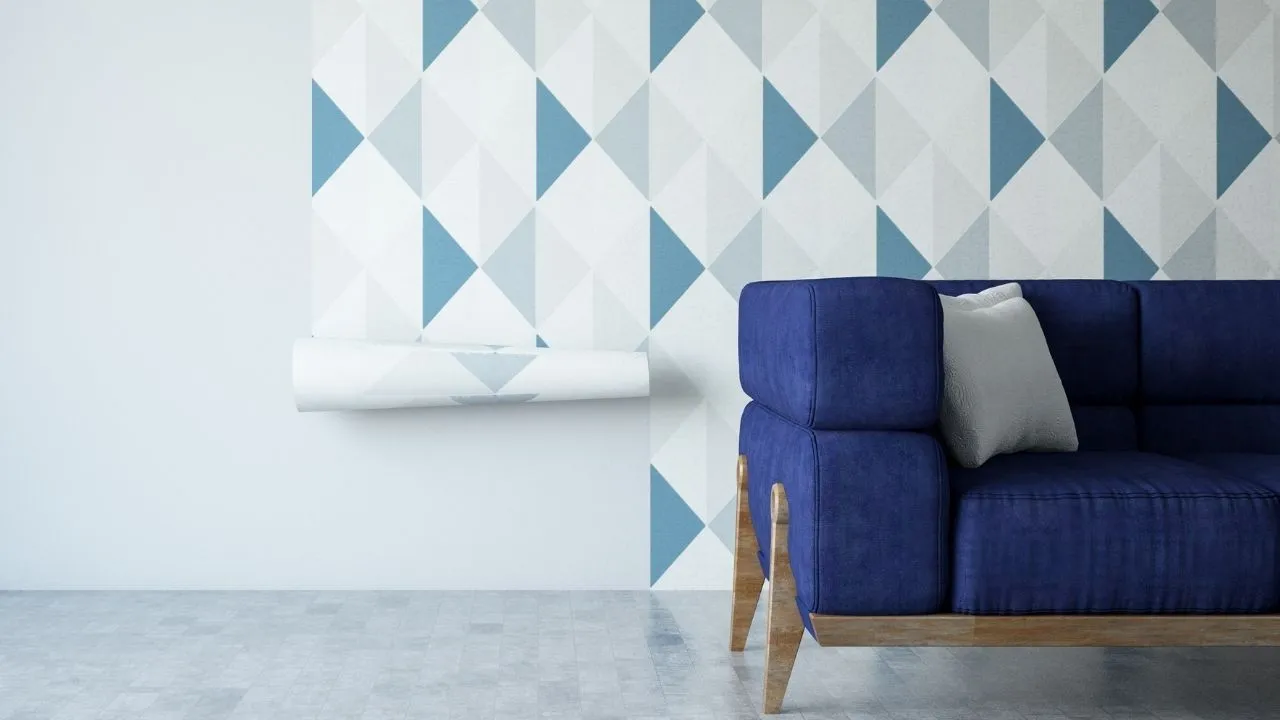 Sala de estar decorada com um sofá azul moderno e uma parede parcialmente coberta por um revestimento geométrico em tons de azul e cinza.
